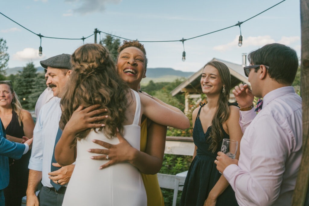 A photo of a wedding guest huggging a bride taken by a documentary style wedding photographer