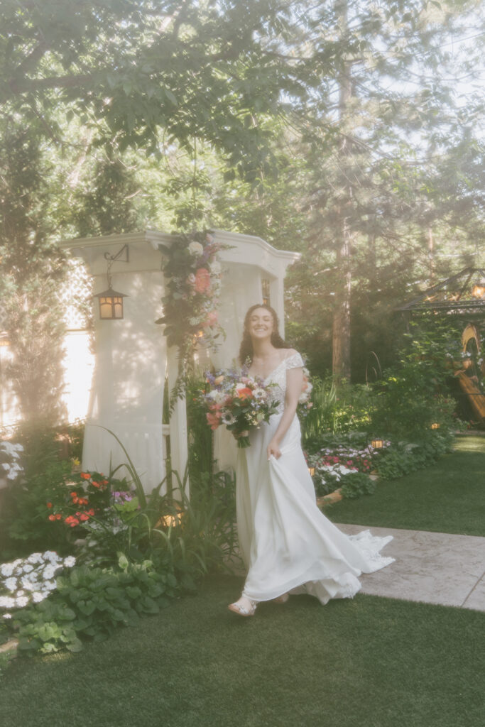 Bride walks across flower garden during her June wedding in Colorado.