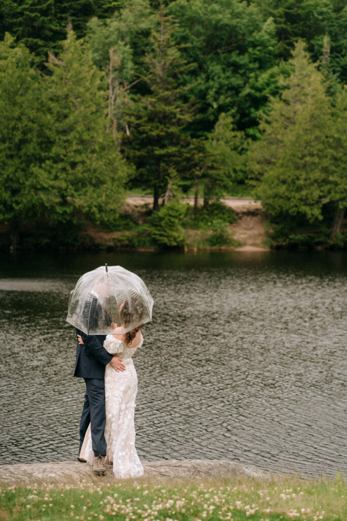 Bride and groom stand under an umbrella during their spring elopement in Colorado.